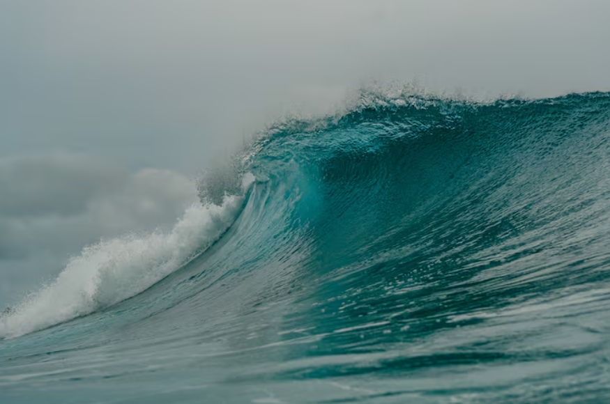 how ocean waves form with a large wave crest breaking across open water