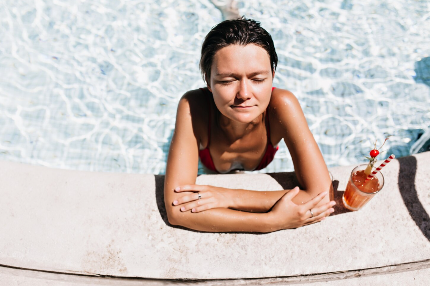 Effects of staying in water too long shown by a swimmer resting at the pool edge.